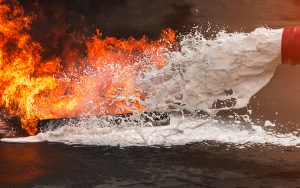 Schiuma antincendio spruzzata sulle fiamme. Le vernici ignifughe sono utili strumenti di prevenzione anti incendio