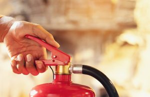 Primo piano di una mano che aziona un estintore antincendio