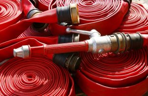 Diverse manichette antincendio dei Vigili del Fuoco, rosse e arrotolate