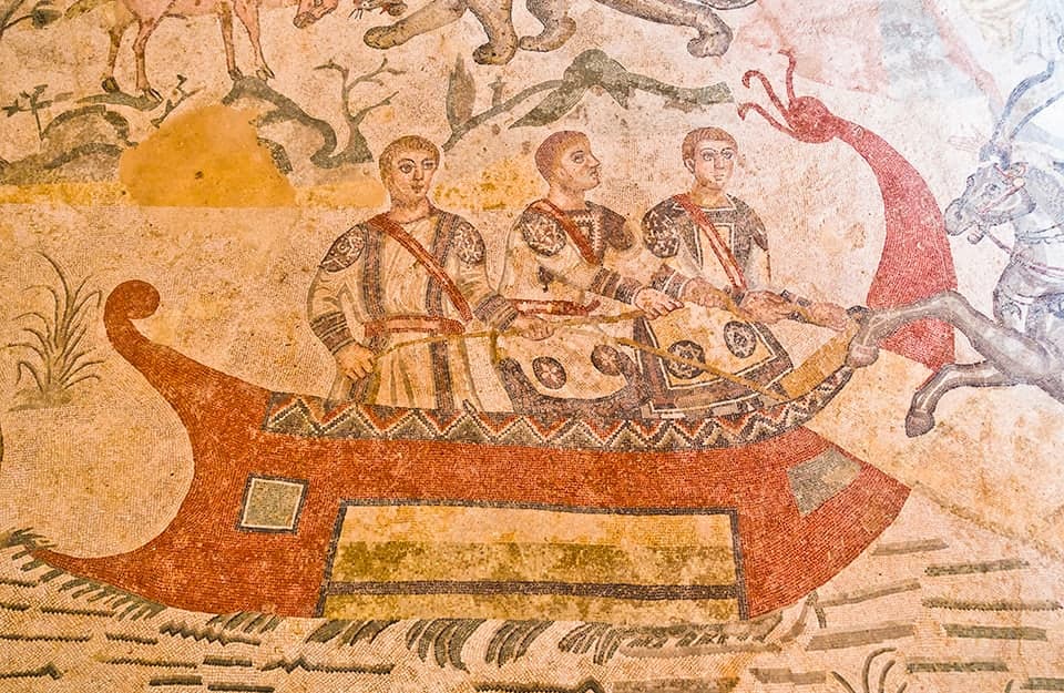 Un antico mosaico d'epoca romana che mostra una nave e tre persone a bordo
