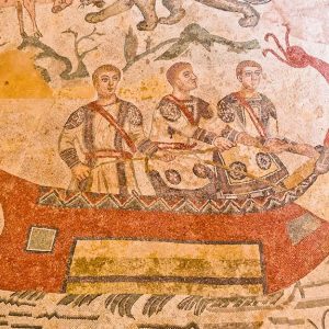 Un antico mosaico d'epoca romana che mostra una nave e tre persone a bordo