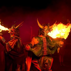Spettacolo teatrale con attori vestiti da demoni che mangiano il fuoco