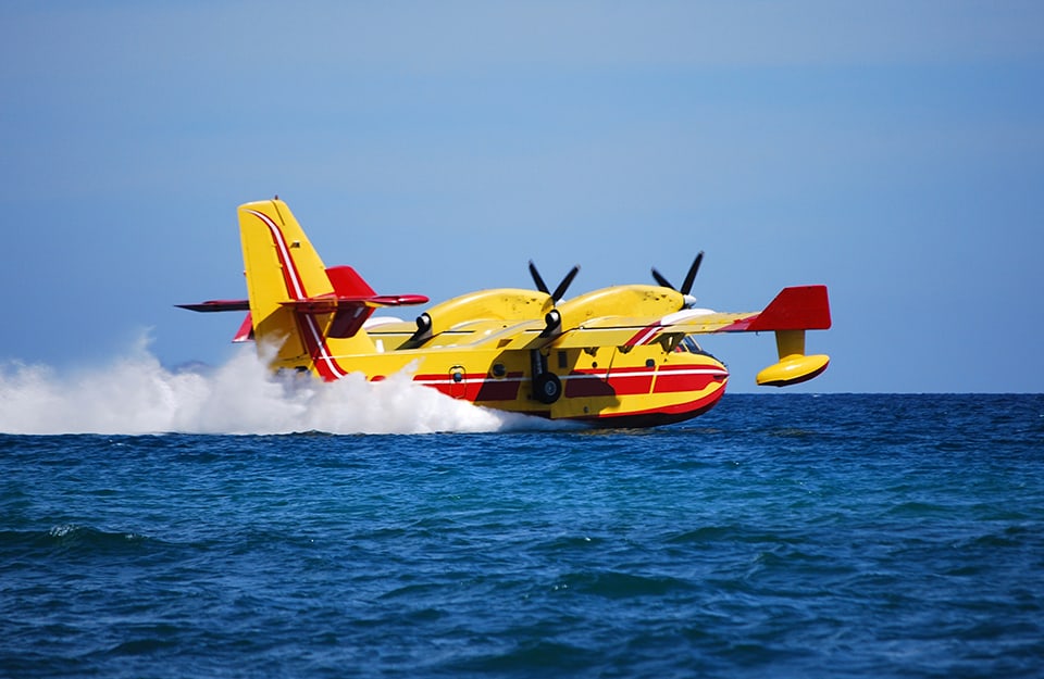 Un canadair mentre si rifornisce volando sul pelo dell'acqua