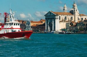 Un mezzo natante dei Vigili del Fuoco di Venezia con sullo sfondo il panorama della città