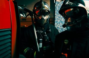 Due pompieri altamente equipaggiati e con visiera a specchio pronti per intervenire