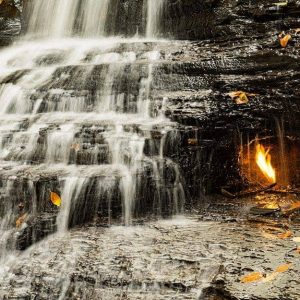 Vista della fiamma all'interno della grotta sovrastata dalla cascata delle Eternal Flame Falls, negli Stati Uniti