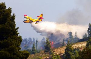 Un Canadair interviene gettando acqua durante un incendio boschivo in Italia