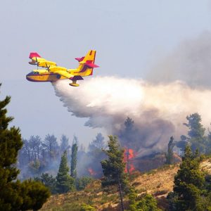 Un Canadair interviene gettando acqua durante un incendio boschivo in Italia