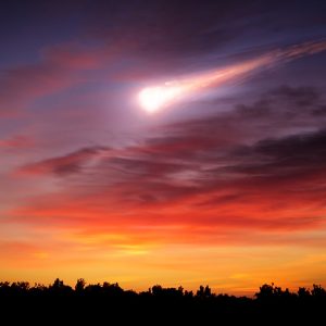 Rappresentazione immaginaria di una cometa che brucia in cielo durante il tramonto