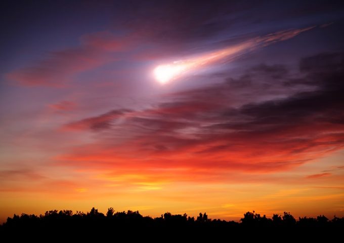 Rappresentazione immaginaria di una cometa che brucia in cielo durante il tramonto