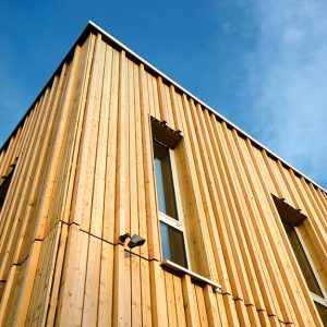 Vista dal basso di due facciate di un edificio in legno costruito secondo i principi della bioedilizia