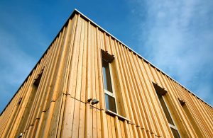 Vista dal basso di due facciate di un edificio in legno costruito secondo i principi della bioedilizia