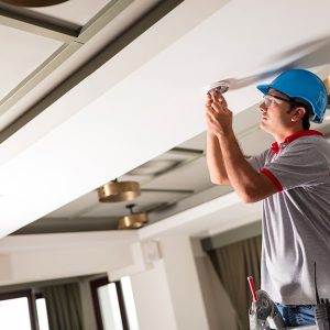 Un tecnico sta installando un rilevatore di fumi sul soffito