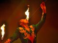 Esibizione di un mangiafuoco del circo, che si sta mettendo in bocca un bastone con una fiamma