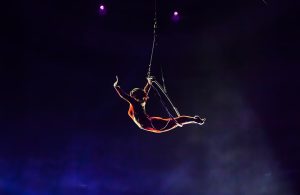 Una trapezista che si sta esibendo sul trapezio di un circo