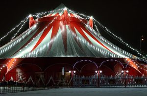 Un tendone da circo bianco e rosso illuminato di notte