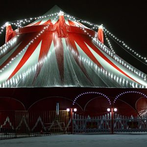 Un tendone da circo 
bianco e rosso illuminato di notte