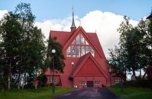 La chiesa di Kiruna, in Svezia, nel suo caratteristico colore rosso e lo stile neogotico, in mezzo agli alberi