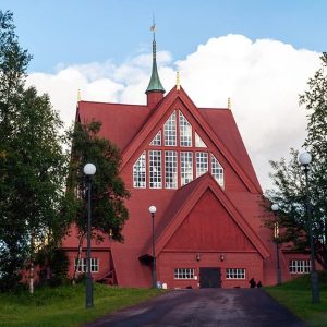 La chiesa di Kiruna, in Svezia, nel suo caratteristico colore rosso e lo stile neogotico, in mezzo agli alberi