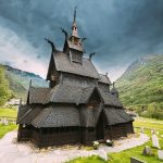La Stavkirke (chiesa in legno) di Borgund, in Norvegia, da una vista angolata in un paesaggio dall'atmosfera drammatica