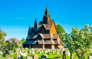 La Stavkirke di Heddal, in Norvegia, circondata da alberi e dalle lapidi del cimitero circostante