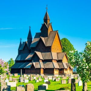 La Stavkirke di Heddal, in Norvegia, circondata da alberi e dalle lapidi del cimitero circostante