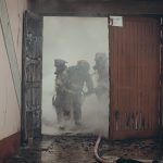 Tre pompieri peruviani durante un intervento in un vecchio edificio invaso dal fumo