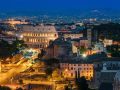 Roma, di sera, illuminata e vista dall'alto, con il Colosseo al centro dell'immagine