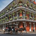 Una carrozza passa davanti a un'antico palazzo in stile coloniale nelle strade del Quartiere francese di New Orleans