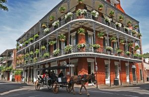 Una carrozza passa davanti a un'antico palazzo in stile coloniale nelle strade del Quartiere francese di New Orleans