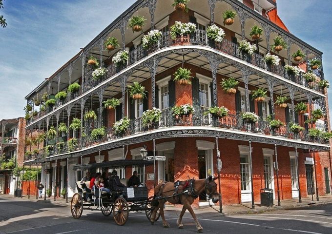 Una carrozza passa davanti a un'antico palazzo in stile coloniale nelle strade del Quartiere francese di New Orleans