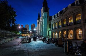 Un'incantevole vista notturna di una strada nel centro di New Orleans, tra locali, chiese e carrozze