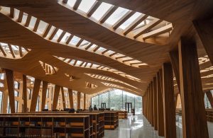Una biblioteca o un archivio pubblico con una grande sala dall'architettura in legno e vetro