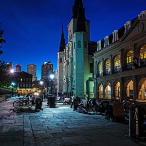 Un'incantevole vista notturna di una strada nel centro di New Orleans, tra locali, chiese e carrozze