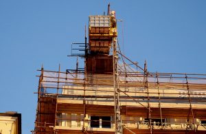 Vista dal basso del tetto di un edificio tutelato in fase di restauro con dei ponteggi