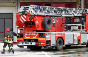 Un camion dei Vigili del Fuoco con due pompieri che stanno correndo durante un'esercitazione