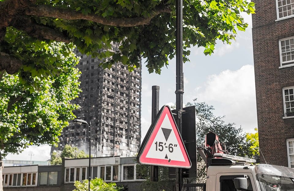 Scorcio su una strada di North Kensington, a Londra, con sullo sfondo i resti carbonizzati della Grenfell Tower dopo l'incendio