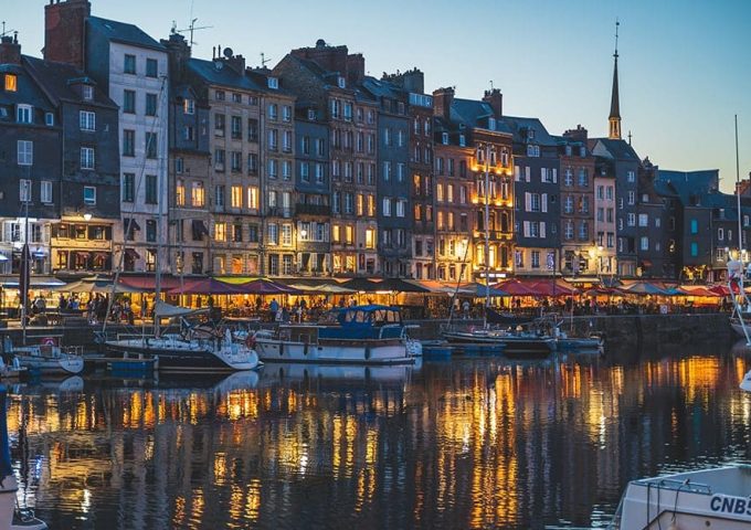 Vista notturna su un canale di Copenaghen, in Danimarca, con palazzi illuminati, acqua e imbarcazioni