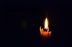 La fiamma di una candela accesa nel buio