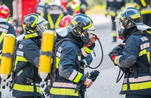Dei Vigili del Fuoco italiani equipaggiati con casco e respiratore durante un'esercitazione