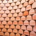 Una parete curva ricoperta da pannelli fonoassorbenti in legno di forma semicircolare