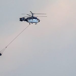 Un elicottero sta trasportando acqua per spegnere un incendio