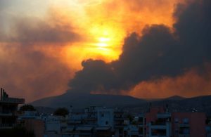 La città greca di Volo con dietro il fumo degli incendi boschivi