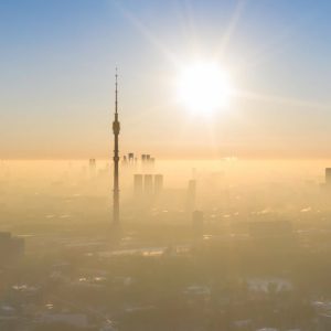 Vista dall'alto della torre di Ostankino, a Mosca, che spicca in un cielo terso sopra alla nebbia che avvolge il resto della città
