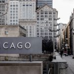 Insegna con la scritta Chicago su una strada della metropoli statunitense, tra palazzi e grattacieli storici