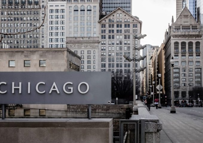 Insegna con la scritta Chicago su una strada della metropoli statunitense, tra palazzi e grattacieli storici