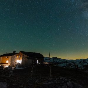 Un rifugio alpino illuminato in una notte stellata in montagna