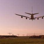 Un aereo in fase di atterraggio, visto da dietro, all'Aeroporto Internazionale di Dusseldorf durante l'alba o il tramonto