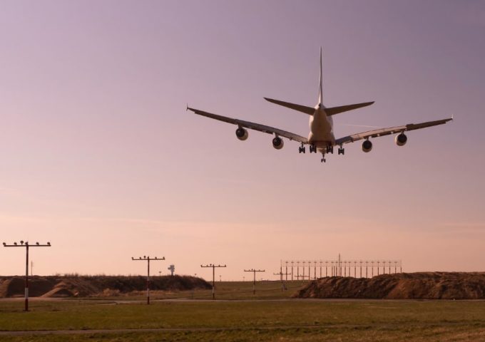 Un aereo in fase di atterraggio, visto da dietro, all'Aeroporto Internazionale di Dusseldorf durante l'alba o il tramonto