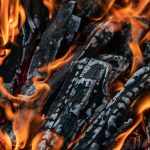 Dei pezzi di legno semicarbonizzato stanno bruciando